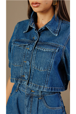 Jaqueta confeccionada em tecido jeans, com modelagem cropped e caimento estruturado. Possui gola tradicional tipo camisa, pesponto marrom, dois bolsos frontais, mangas curtas dobradas, ambas com martingale, permitindo o ajuste da manga como na refer�ncia visual,�al�m de�fechamento frontal por bot�es encapados.